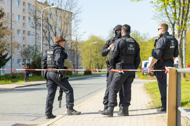 28 April 2026, Saxony, Neustadt: Police officers stand near the scene of the crime after gunshots in the vicinity of an apartment building. Police discovered two dead and one seriously injured person. Photo: Jürgen Lösel/dpa