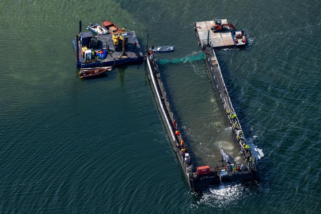 28 April 2026, Mecklenburg-Western Pomerania, Faehrdorf: The humpback whale that stranded in the Baltic Sea has arrived at the barge designated for its transport. The animal moved into the barge through a channel that had been dredged out, after rescuers had pulled it in that direction using straps. Photo: Stefan Sauer/dpa