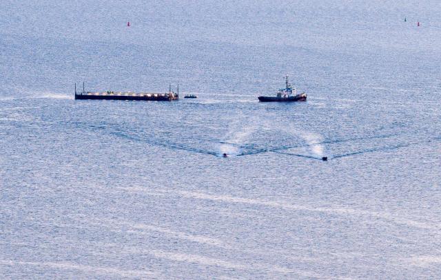 28 April 2026, Mecklenburg-Western Pomerania, Wismar: The ship "Robin Hood" pulls the barge with the beached whale towards the Baltic Sea in the evening. Photo: Bodo Marks/dpa