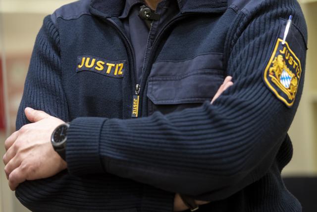 FILED - 17 February 2022, Bavaria, Munich: An employee of the judiciary stands in the courtroom of the Higher Regional Court ahead of a trial. Photo: Lennart Preiss/dpa