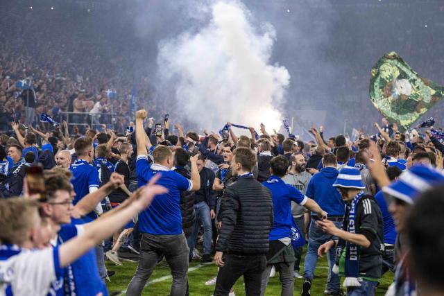 FILED - 07 May 2022, Gelsenkirchen: Schalke fans storm the field to celebrate the team's promotion after the German 2nd Bundesliga soccer match between FC Schalke 04 and FC St. Pauli at the Veltins Arena. Photo: David Inderlied/dpa
