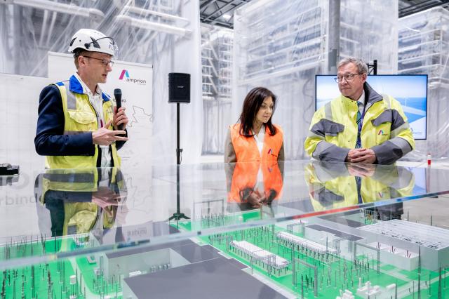 29 April 2026, Lower Saxony, Emden: (L-R) Head of Substation Technology and High-Voltage Direct Current Transmission at Amprion Daniel Eickhoff, Minister for Economic Affairs and Energy Katherina Reiche and CEO of Amprion Christoph Mueller examine a model of the facility in a hall at the construction site of a new converter station. Photo: Hauke-Christian Dittrich/dpa