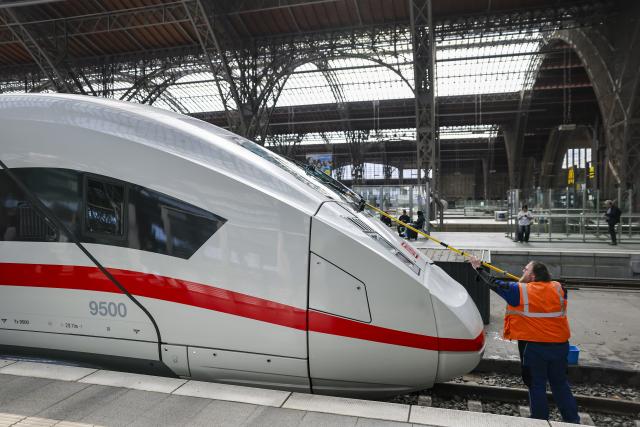 28 April 2026, Saxony, Leipzig: A railroad employee cleans the windshield on an ICE-4 arriving at Leipzig Central Station. Around 400 ICE trains are on the rails every day throughout Germany. To keep the trains clean for more than 370,000 passengers a day, Deutsche Bahn has launched an immediate program for more comfort in long-distance transport. Photo: Jan Woitas/dpa