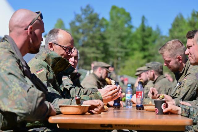 30 April 2026, Lower Saxony, Munster: German Chancellor Friedrich Merz (2-L) visits the army in Munster and talks to soldiers. Merz wants to gain an impression of the operational readiness of the land forces and the Army's plans. Photo: Philipp Schulze/dpa