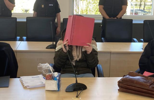 30 April 2026, Mecklenburg-Western Pomerania, Rostock: The 30-year-old defendant in the Fabian case in Rostock holds a folder in front of her face in court. The trial of a 30-year-old woman who allegedly killed eight-year-old Fabian from Güstrow in October 2025 has continued at Rostock District Court. Photo: Helmut Reuter/dpa
