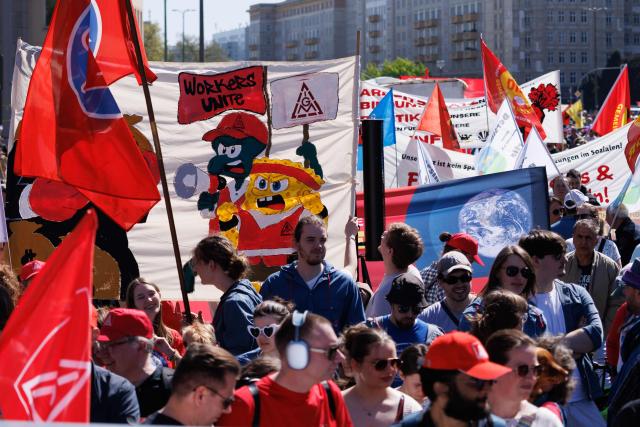 01 May 2026, Berlin: Participants carry various flags and banners during a demonstration organized by the German Trade Union Confederation (DGB) under the slogan "First our jobs, then your profits". The occasion is a nationwide trade union rally to mark International Workers' Day. Photo: Carsten Koall/dpa