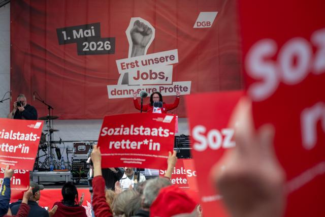 01 May 2026, Bavaria, Nuremberg: DGB head Yasmin Fahimi clenches both fists while signs reading "Welfare state savior" are held up in the audience. The occasion is a nationwide trade union rally to mark International Workers' Day. Photo: Pia Bayer/dpa