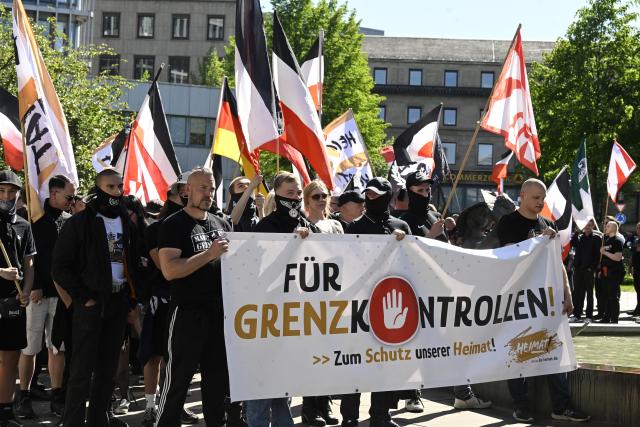 01 May 2026, North Rhine-Westphalia, Essen: People with flags and banners take part in a far-right demonstration, while counter-demonstrators protest to mark International Workers' Day. Photo: Roberto Pfeil/dpa