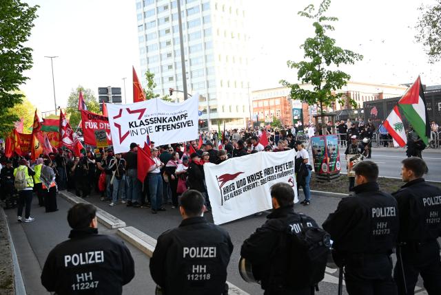 01 May 2026, Hamburg: Participants march with signs and banners at a demonstration under the slogan "War and crisis are systemic. United as a class: Fight for socialism!". On May 1, several demonstrations and events will take place across the country. Photo: Daniel Bockwoldt/dpa