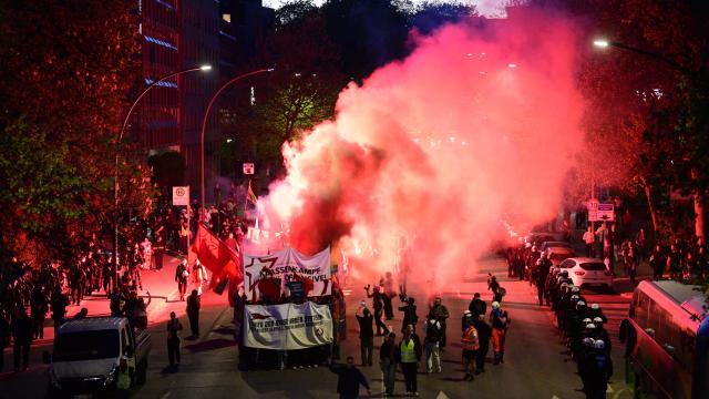 01 May 2026, Hamburg: Participants set off fireworks during a demonstration under the slogan "War and crisis are systemic. United as a class: Fight for socialism!". On May 1, several demonstrations and events will take place across the country. Photo: Daniel Bockwoldt/dpa