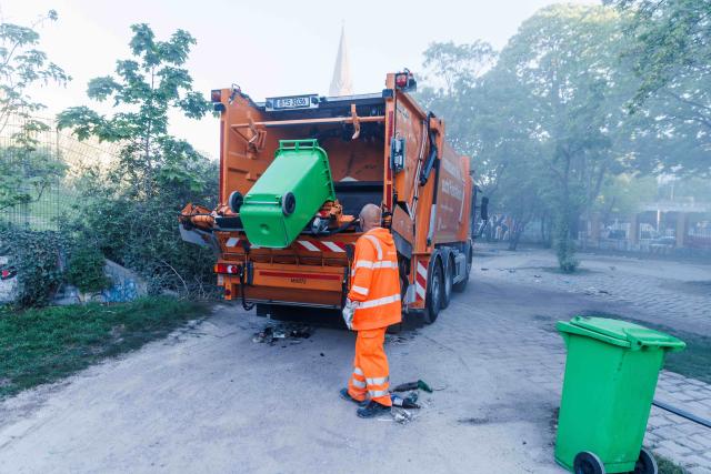 02 May 2026, Berlin: An employee empties a garbage can in Goerlitzer Park containing mostly empty glass bottles in the early hours of the morning on the day after May 1st. Photo: Carsten Koall/dpa