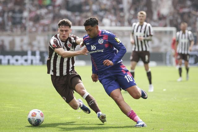 03 May 2026, Hamburg: Mainz' Nadiem Amiri and St. Pauli's Arkadiusz Pyrka battle for the ball during the German Bundesliga soccer match between the FC St. Pauli and FSV Mainz 05 at the Millerntor Stadium. Photo: Christian Charisius/dpa - IMPORTANT NOTICE: DFL and DFB regulations prohibit any use of photographs as image sequences and/or quasi-video.