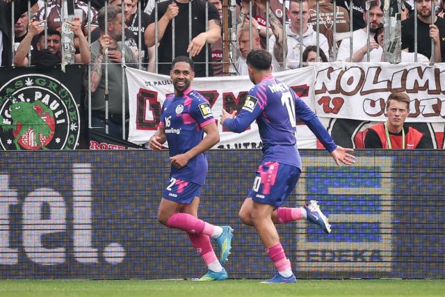 03 May 2026, Hamburg: Mainz' Phillipp Mwene (L) celebrates scoring his side's second with Nadiem Amiri during the German Bundesliga soccer match between the FC St. Pauli and FSV Mainz 05 at the Millerntor Stadium. Photo: Christian Charisius/dpa - IMPORTANT NOTICE: DFL and DFB regulations prohibit any use of photographs as image sequences and/or quasi-video.