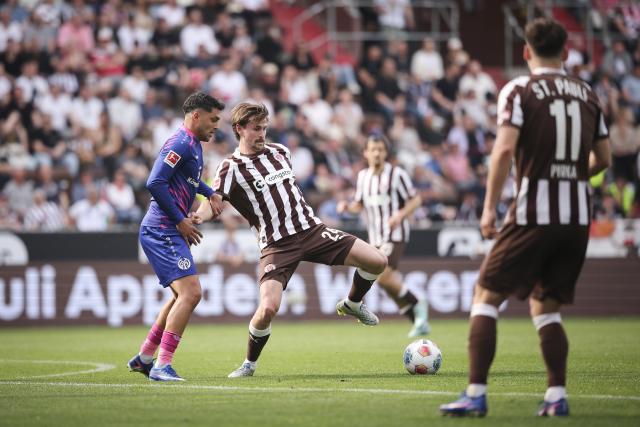 03 May 2026, Hamburg: Mainz' Nadiem Amiri (L) and St. Pauli's Connor Metcalfe battle for the ball during the German Bundesliga soccer match between the FC St. Pauli and FSV Mainz 05 at the Millerntor Stadium. Photo: Christian Charisius/dpa - IMPORTANT NOTICE: DFL and DFB regulations prohibit any use of photographs as image sequences and/or quasi-video.