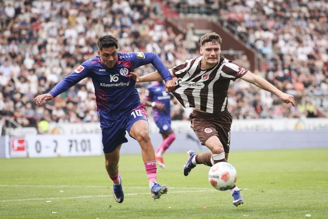 03 May 2026, Hamburg: St. Pauli's Arkadiusz Pyrka (R) and Mainz' Nadiem Amiri battle for the ball during the German Bundesliga soccer match between the FC St. Pauli and FSV Mainz 05 at the Millerntor Stadium. Photo: Christian Charisius/dpa - IMPORTANT NOTICE: DFL and DFB regulations prohibit any use of photographs as image sequences and/or quasi-video.