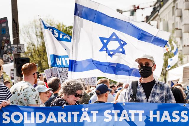 03 May 2026, Berlin: Participants hold a banner reading "Solidarity instead of hate" and wave Israeli flags during the vigil "Against all anti-Semitism - solidarity with Jews" in Berlin, after anti-Semitic lettering was seen on a residential building. Photo: Carsten Koall/dpa