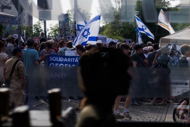 03 May 2026, Berlin: Participants hold a banner reading "Solidarity instead of hate" and wave Israeli flags during the vigil "Against all anti-Semitism - solidarity with Jews" in Berlin, after anti-Semitic lettering was seen on a residential building. Photo: Carsten Koall/dpa