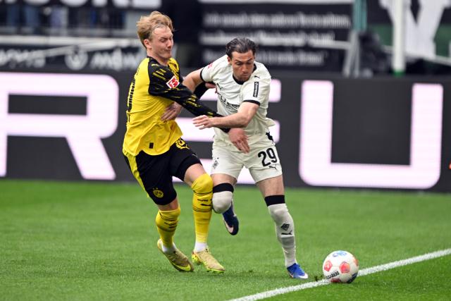 03 May 2026, North Rhine-Westphalia, Moenchengladbach: Moenchengladbach's Joe Scally (R) and Dortmund's Julian Brandt battle for the ball during the German Bundesliga soccer match between Borussia Moenchengladbach and Borussia Dortmund at Borussia-Park. Photo: Federico Gambarini/dpa - IMPORTANT NOTE: In accordance with the regulations of the DFL German Football League and the DFB German Football Association, it is prohibited to utilize or have utilized photographs taken in the stadium and/or of the match in the form of sequential images and/or video-like photo series.