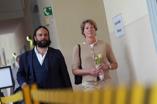 04 May 2026, Hamburg: Christina Block (R), a German restaurateur and entrepreneur, holds flowers she had previously received for her birthday and walks with attorney Ingo Bott (L), her defense counsel, to the courtroom for the trial on charges of alleged child abduction at the Hamburg Regional Court. In a covert operation on New Year's Eve 2023/24, two children of Block were brought from Denmark to Germany, and the trial over the alleged abduction is currently underway at the Hamburg Regional Court. Photo: Marcus Brandt/dpa