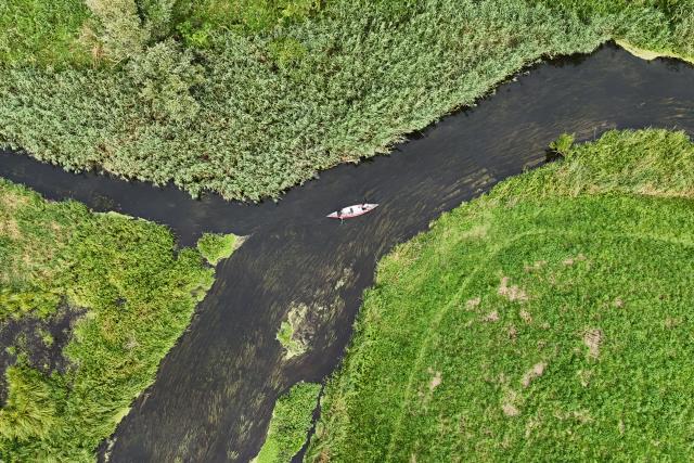 FILED - 07 August 2025, Mecklenburg-Western Pomerania, Weitendorf: FILE PHOTO - An aerial photo shows a kayak drifting across the Warnow. Photo: Philip Dulian/dpa