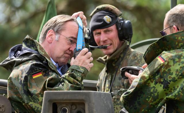 04 May 2026, Lower Saxony, Munster: German Minister of Defence, Boris Pistorius (L), puts on protective goggles before taking a ride on a German Military (Bundeswehr) tank. Photo: Philipp Schulze/dpa