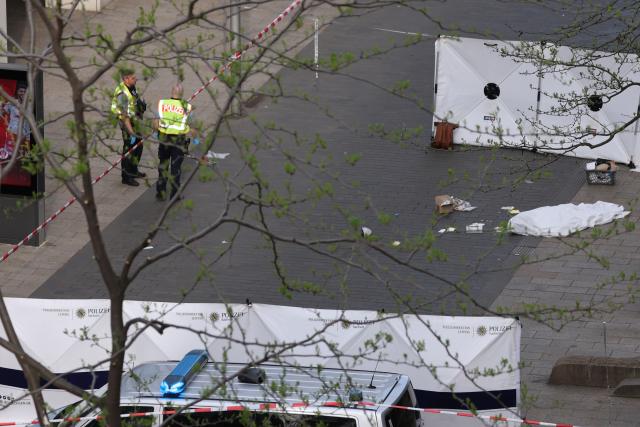 04 May 2026, Saxony, Leipzig: Police officers stand next to a body bag containing a corpse at the spot where a car drove into a group of people in Leipzig. Photo: Jan Woitas/dpa