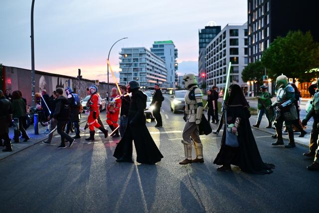 04 May 2026, Berlin: Cosplayers walk across a street at the fan event for the Disney film "Star Wars: The Mandalorian and Grogu". Photo: Sebastian Gollnow/dpa