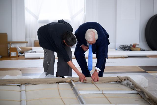 05 May 2026, Berlin: Restorer Hana Streicher (L) explains to German President Frank-Walter Steinmeier the construction method of one of the two large works of art by artist Gotthard Graubner (1930-2013) entitled "Encounters" in the Great Hall of Bellevue Palace after it has been taken down. The palace is currently being prepared for its long-term renovation. The large color space bodies were created by Gotthard Graubner in 1988 at the request of Federal President von Weizsaecker directly in Bellevue Palace. Photo: Bernd von Jutrczenka/dpa