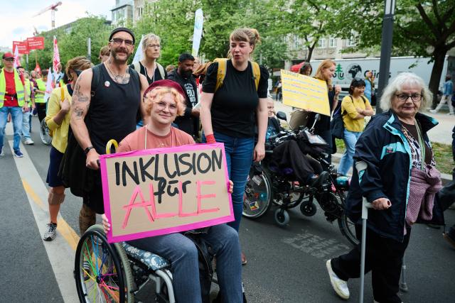 05 May 2026, Berlin: A person with a disability holds a placard reads "Inclusion for All" at a demonstration in the city center under the slogan "Together for Greater Inclusion" to mark the European Day of Protest for the Equality of People with Disabilities. Photo: Annette Riedl/dpa