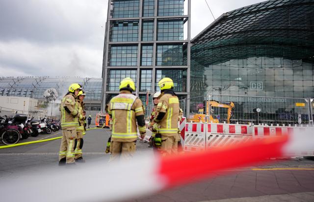 05 May 2026, Berlin: Firefighters stand in front of Berlin Central Station, after fire in a large garbage bin in front of the central station caused huge billows of smoke over the city. Photo: Kay Nietfeld/dpa