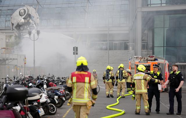 05 May 2026, Berlin: Firefighters stand in front of Berlin Central Station, after fire in a large garbage bin in front of the central station caused huge billows of smoke over the city. Photo: Kay Nietfeld/dpa