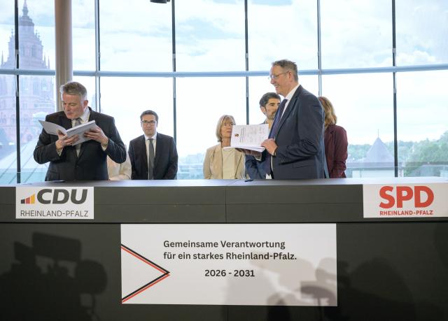 06 May 2026, Rhineland-Palatinate, Mainz: Gordon Schneider (L) and outgoing Minister President Alexander Schweitzer (R) present the joint coalition agreement for the government in Rhineland-Palatinate. Officials from both parties stand in the background. Photo: Hannes P. Albert/dpa