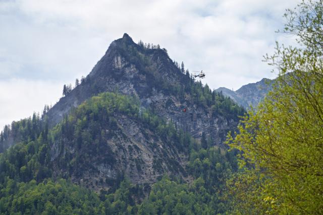06 May 2026, Bavaria, Ruhpolding: Helicopters drop water to fight the large-scale wildfire on the 1,270-meter-high Sauruesselkopf in the Chiemgau Alps. Photo: Uwe Lein/dpa