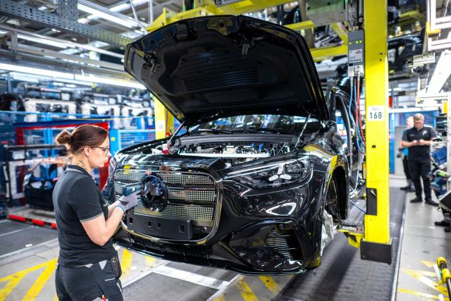 06 May 2026, Bremen: Employees in Hall 9 at the Mercedes-Benz plant in Bremen work on an assembly line producing GLC models, including the all-electric GLC. Photo: Sina Schuldt/dpa