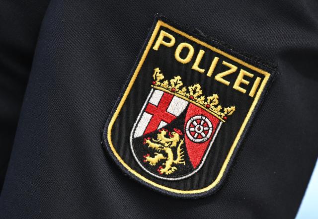 FILED - 06 February 2024, Rhineland-Palatinate, Mainz: FILE PHOTO - The coat of arms of the Rhineland-Palatinate police is attached to a police officer's jacket. German police say they have deployed to tackle a suspected hostage situation at a bank in the western German town of Sinzig. Photo: Arne Dedert/dpa