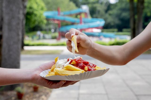 FILED - 18 June 2020, Berlin: FILE PHOTO - Children at the Humboldthain Outdoor Pool eat French fries with ketchup and mayonnaise from the snack bar. French fries should cost no more than 5.50 euros at most outdoor pools. Photo: Christoph Soeder/dpa