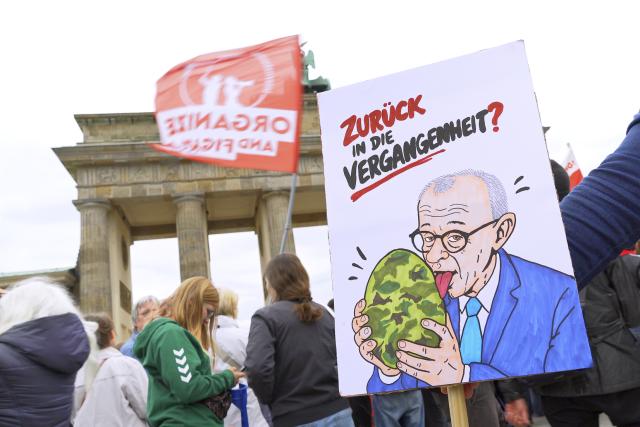 08 May 2026, Berlin: A demonstrator holds up a sign with explicit language directed at German Chancellor Friedrich Merz as people gather in front of the Brandenburg Gate in Berlin to protest against the draft. Photo: Michael Ukas/dpa