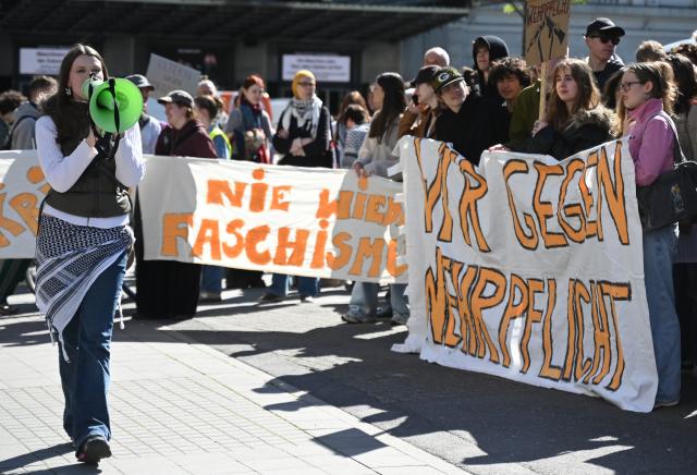 08 May 2026, Hamburg: Participants hold up banners and posters in the city center during the 'School Strike Against Conscription' demonstration. Photo: Katrin Luxenburger/dpa