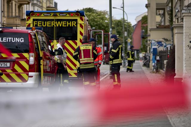 08 May 2026, Brandenburg, Potsdam: Police and fire department personnel stand on a street in Potsdam after a suspicious object was discovered in an apartment, with a residential building in western Potsdam cordoned off over a wide area. Photo: Michael Ukas/dpa