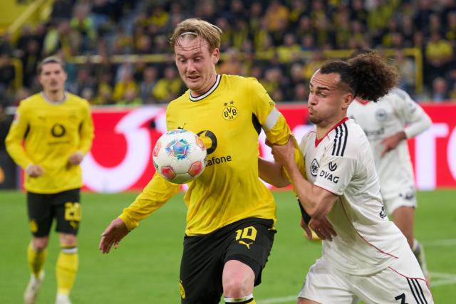 08 May 2026, Dortmund: Borussia Dortmund's Julian Brandt and Eintracht Frankfurt's Arthur Theate battle for the ball during the German Bundesliga soccer match between Borussia Dortmund and Eintracht Frankfurt at the Signal Iduna Park. Photo: Bernd Thissen/dpa - IMPORTANT NOTICE: DFL and DFB regulations prohibit any use of photographs as image sequences and/or quasi-video.