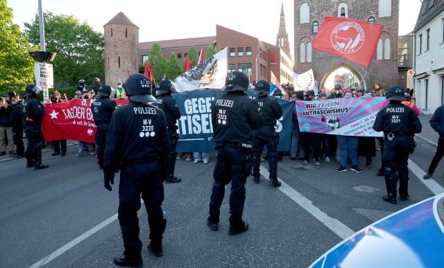 08 May 2026, Mecklenburg-Western Pomerania, Demmin: Police officers stand in front of a road blockade by counter-demonstrators during the the so-called funeral march by Right-wing extremists, organized by the The Homeland
(Die Heimat) party. Photo: Bernd Wüstneck/dpa