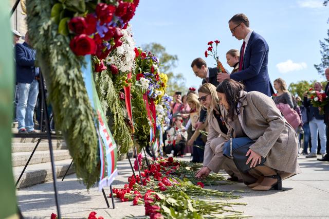 09 May 2026, Berlin: People take part in a wreath-laying ceremony at the Soviet War Memorial near the Brandenburg Gate during a memorial march honoring Soviet soldiers who died in the Second World War, placing red carnations on the ground in front of the wreaths. Photo: Michael Ukas/dpa