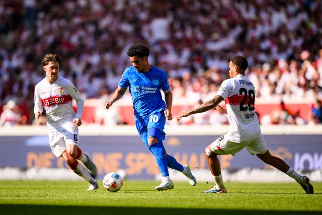09 May 2026, Stuttgart: Bayer Leverkusen's Malik Tillman (C) in action against Stuttgart's Angelo Stiller (L) and Nikolas Nartey during the German Bundesliga soccer match between VfB Stuttgart and Bayer 04 Leverkusen at the MHPArena. Photo: Tom Weller/dpa - IMPORTANT NOTICE: DFL and DFB regulations prohibit any use of photographs as image sequences and/or quasi-video.
