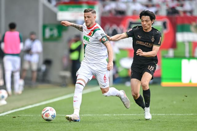 09 May 2026, Bavaria, Augsburg: Augsburg's Jeffrey Gouweleeuw in action against Moenchengladbach's Shuto Machino during the German Bundesliga soccer match between FC Augsburg and Borussia Moenchengladbach at the WWK-Arena. Photo: Harry Langer/dpa - IMPORTANT NOTICE: DFL and DFB regulations prohibit any use of photographs as image sequences and/or quasi-video.
