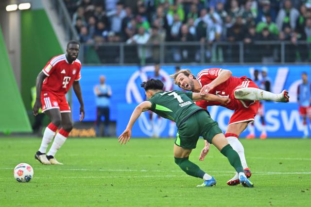 09 May 2026, Lower Saxony, Wolfsburg: Wolfsburg's Kento Shiogai (L) and Bayern Munich's Harry Kane battle for the ball during the German Bundesliga soccer match between VfL Wolfsburg and Bayern Munich at the Volkswagen Arena. Photo: Swen Pförtner/dpa - IMPORTANT NOTICE: DFL and DFB regulations prohibit any use of photographs as image sequences and/or quasi-video.