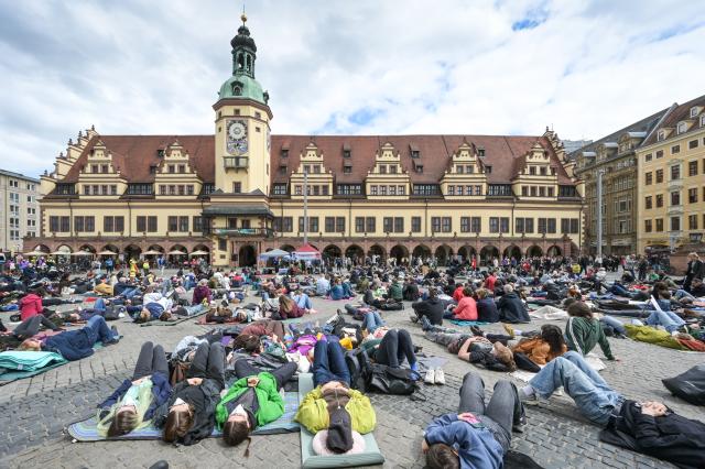 09 May 2026, Saxony, Leipzig: People take part in a die-in demonstration at Leipzig's market square, to draw attention to the serious illness ME/CFS and the consequences of Long Covid. Photo: Heiko Rebsch/dpa