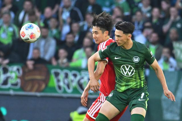 09 May 2026, Lower Saxony, Wolfsburg: Wolfsburg's Kento Shiogai (R) and Bayern Munich's Hiroki Ito battle for the ball during the German Bundesliga soccer match between VfL Wolfsburg and Bayern Munich at the Volkswagen Arena. Photo: Swen Pförtner/dpa - IMPORTANT NOTICE: DFL and DFB regulations prohibit any use of photographs as image sequences and/or quasi-video.