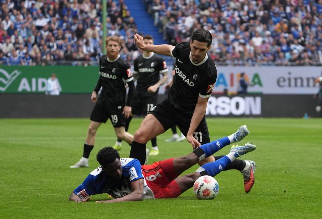 10 May 2026, Hamburg: Freiburg's Igor Matanovic and Hamburger's Albert Lokonga battle for the ball during the German Bundesliga soccer match between Hamburger SV and SC Freiburg at Volksparkstadion. Photo: Marcus Brandt/dpa - IMPORTANT NOTE: In accordance with the regulations of the DFL German Football League and the DFB German Football Association, it is prohibited to utilize or have utilized photographs taken in the stadium and/or of the match in the form of sequential images and/or video-like photo series.