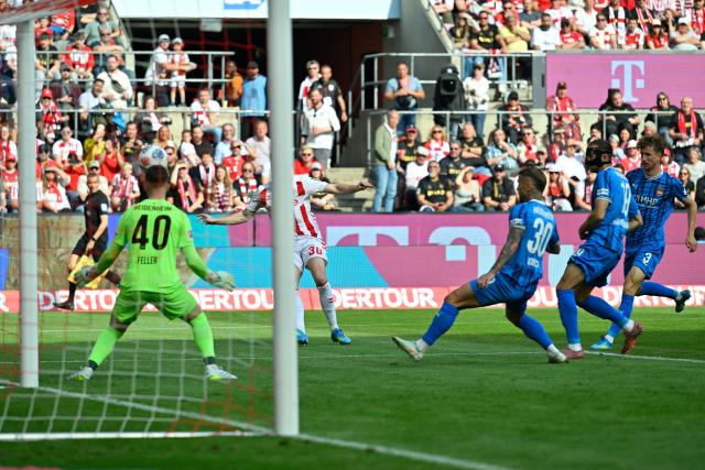 10 May 2026, North Rhine-Westphalia, Cologne: Cologne's Marius Buelter (2nd L) scores scores his side's first goal during the German Bundesliga soccer match between 1.FC Cologne and 1.FC Heidenheim at RheinEnergieStadion. Photo: Ulrich Hufnagel/dpa - IMPORTANT NOTE: In accordance with the regulations of the DFL German Football League and the DFB German Football Association, it is prohibited to utilize or have utilized photographs taken in the stadium and/or of the match in the form of sequential images and/or video-like photo series.