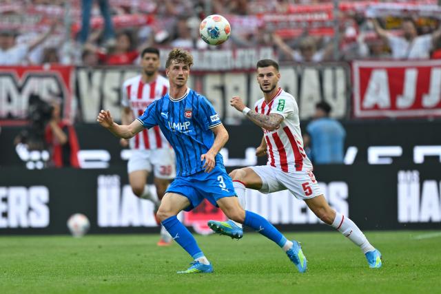 10 May 2026, North Rhine-Westphalia, Cologne: Heidenheim's Jan Schoeppner (L) and Cologne's Tom Krauss battle for the ball during the German Bundesliga soccer match between 1.FC Cologne and 1.FC Heidenheim at RheinEnergieStadion. Photo: Ulrich Hufnagel/dpa - IMPORTANT NOTE: In accordance with the regulations of the DFL German Football League and the DFB German Football Association, it is prohibited to utilize or have utilized photographs taken in the stadium and/or of the match in the form of sequential images and/or video-like photo series.